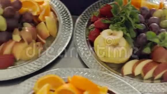 新鲜可口的梨橘子苹果草莓和葡萄放在一个大银盘上上面放着薄荷视频的预览图