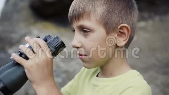 男孩站在山顶看着望远镜视频的预览图