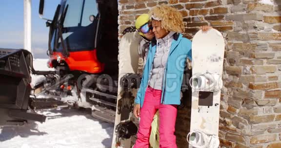 一对亲密的夫妇拿着滑雪板对着车库摆姿势视频的预览图
