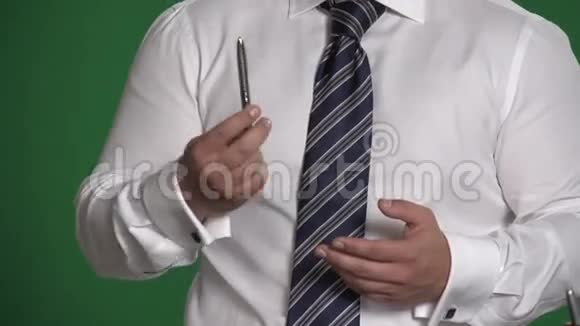 在绿色背景上用钢笔装饰男性的手视频的预览图