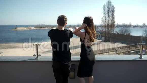 恋爱中的一对年轻夫妇正站在悬崖上望着大海做梦视频的预览图