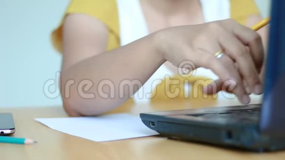 女性的手在笔记本电脑上打字和纸上写字隐喻网络与商业营销理念视频的预览图