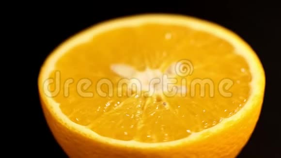 橙色在一个区域靠近明亮的橙色在黑色背景上旋转明亮的柑橘橘色视频的预览图