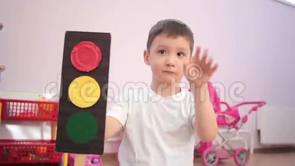 小男孩手里拿着玩具交通灯坐着挥手视频的预览图