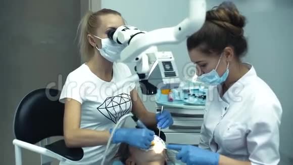 牙科医生和诊所的助手一起用参考监视器工作视频的预览图