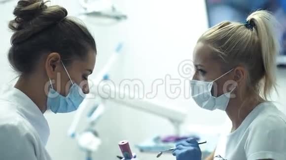 牙科医生椅子上有助理检查女孩牙齿的牙医视频的预览图