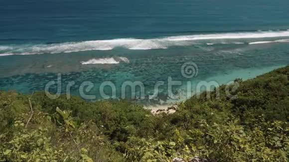 从悬崖上看到一个小小的海滩和清澈的蓝色海洋视频的预览图