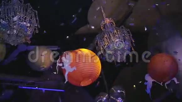 吊灯球丘比特的形象挂在夜总会纸屑慢动作视频的预览图