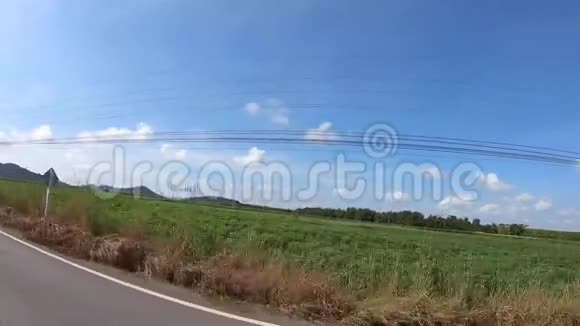 阳光明媚的一天一辆汽车在乡间小路上行驶视频的预览图