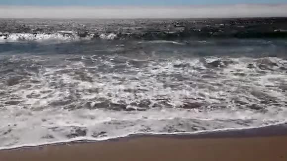 沙滩上的波浪冲刷填补框架视频的预览图