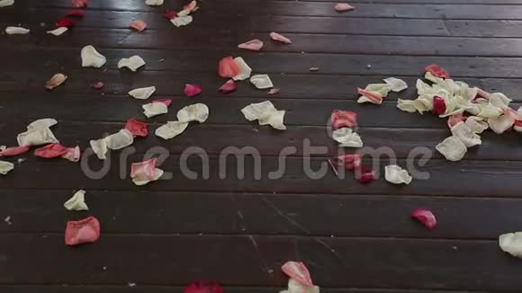 木地板上的玫瑰花瓣带滑块的高清镜头视频的预览图