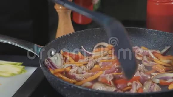 厨师把各种蔬菜和肉用黄油烤在热煎锅上视频的预览图