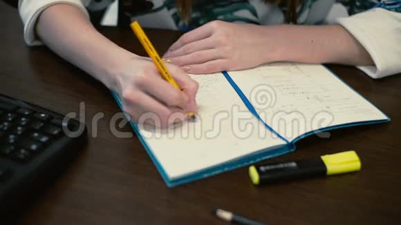 女孩在草地背景上的笔记本上写字视频的预览图