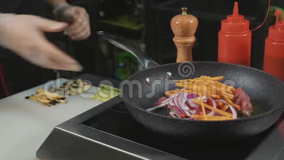 厨师把各种蔬菜和肉用黄油烤在热煎锅上视频的预览图