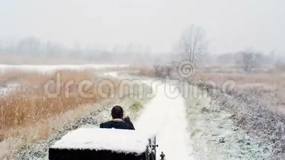 男子在冬季道路上骑一辆马车视频的预览图