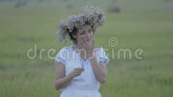戴着花环的少女独自站在空旷的田野里视频的预览图