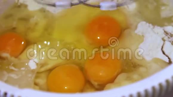 锅中的生鸡蛋是搅拌电动搅拌器近距离观看视频的预览图