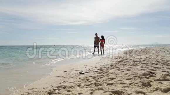 情侣在沙滩上牵手交谈男人和女人在海上度假视频的预览图