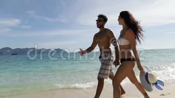 情侣在沙滩上牵手交谈男人和女人在海上度假视频的预览图