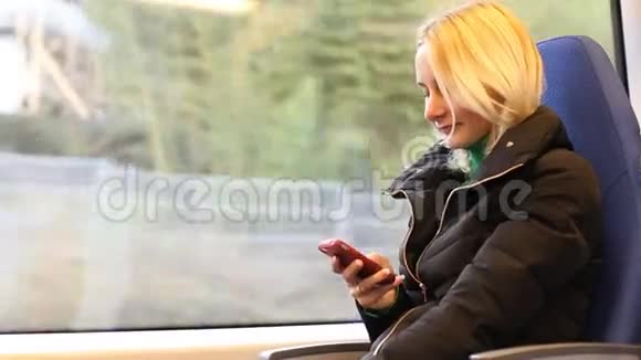 触摸手机短信写作年轻女子在火车上视频的预览图