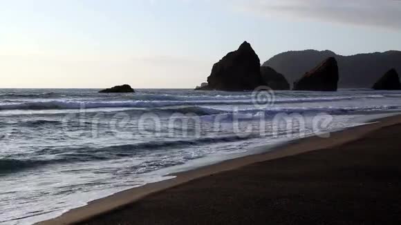 沙丘上的波浪在黄昏区的岩石上视频的预览图
