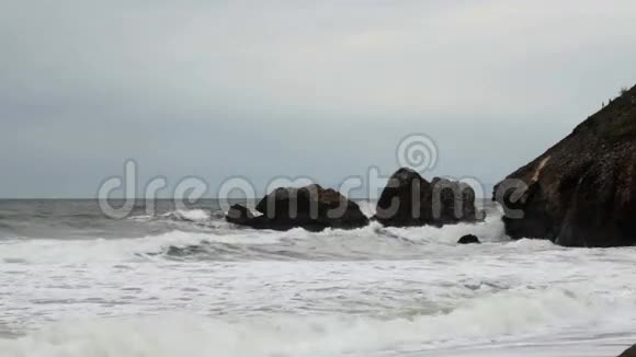 温和的波浪冲击岩石的头部覆盖日视频的预览图