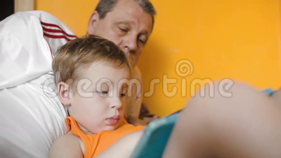 男孩在垫子上玩和爷爷说话视频的预览图