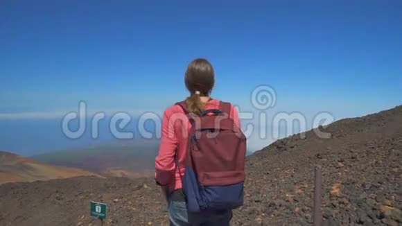 一个背着背包站在山顶的女孩视频的预览图