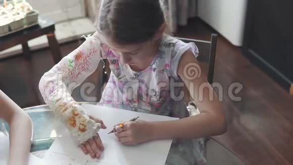 带着绷带的断臂的孩子用彩色铅笔画画手受伤的小女孩视频的预览图