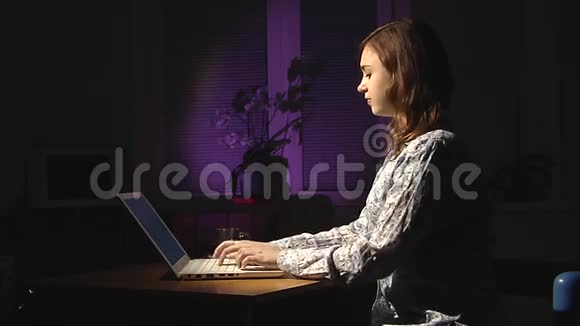 女性手在白色笔记本电脑上打字晚上好视频的预览图