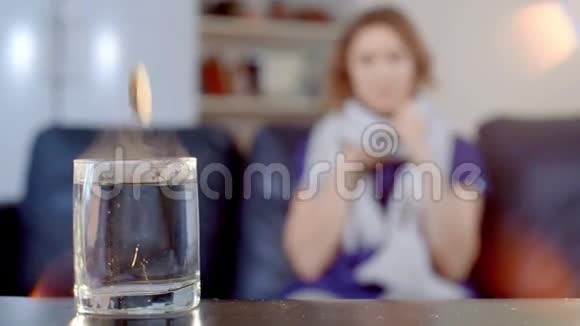 生病的女孩咳嗽看着杯子里的药视频的预览图