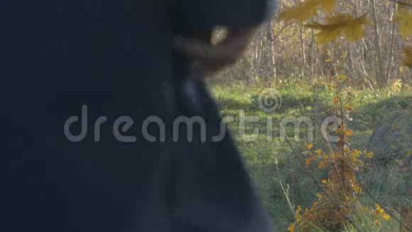 一个男人在秋日走在村里的路上浅焦点视频的预览图
