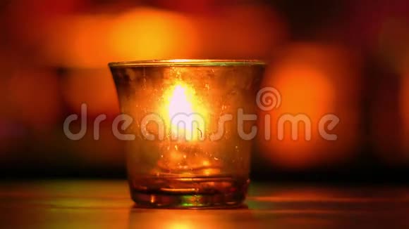 杯子里的蜡烛放在蓝调音乐酒吧的木桌上模糊的后退博克彩色照明慢动作视频的预览图