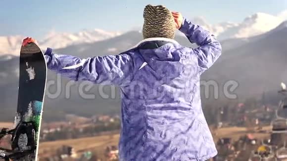 迷人的年轻滑雪板女孩微笑着在镜头中用OK手势视频的预览图