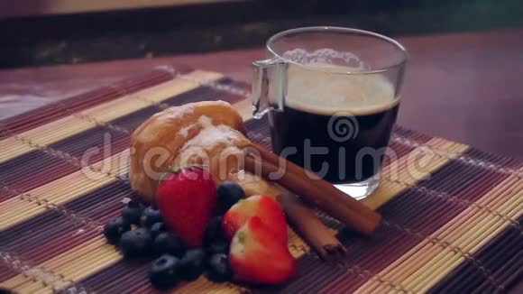 木桌上有牛角面包和浆果的咖啡视频的预览图