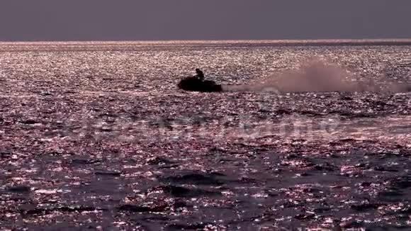 剪影一个骑摩托车的人在海上漂浮视频的预览图