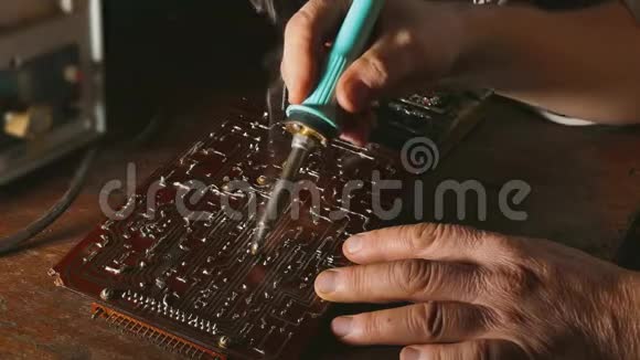 老人修理芯片无线电技师烟来修理烙铁工程师或技师修理视频的预览图