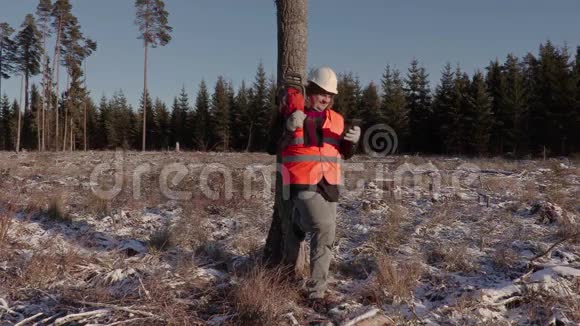 林中树旁拿着电锯笑的伐木工人视频的预览图