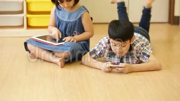 一群小亚洲孩子吃零食一起玩电脑平板电脑视频的预览图