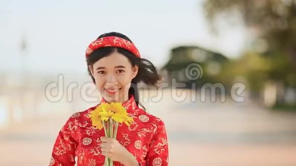 美丽的越南女孩穿着红色的传统服装戴着黄色的花视频的预览图