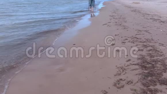 带着登山杖的人走在海边视频的预览图