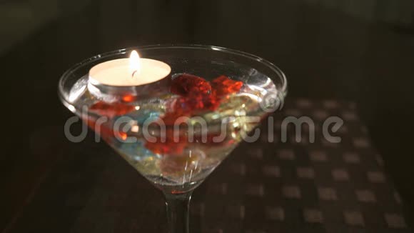 在玻璃中燃烧蜡烛散落的宝石奉献双手和双心视频的预览图