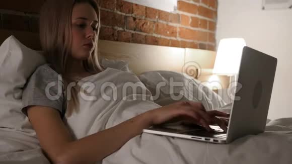头痛疲惫的女人在床上工作视频的预览图