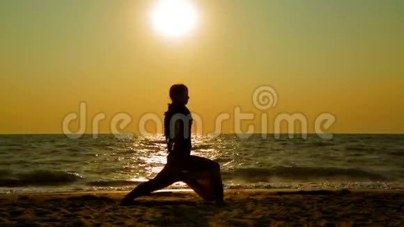 日落沙滩上练习瑜伽的女人视频的预览图