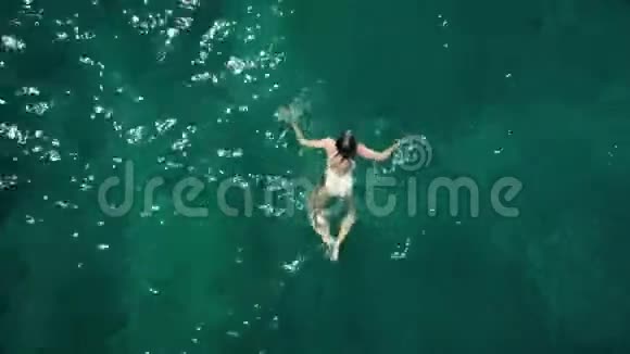 一位年轻女子在海上游泳的高空俯视图视频的预览图