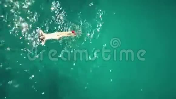 从高空俯瞰一位美丽的年轻女子在海中沐浴视频的预览图