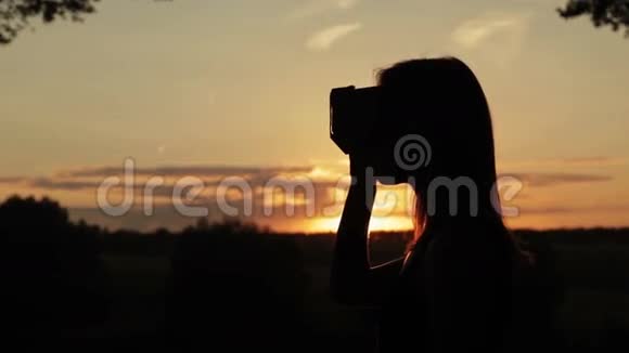 日落时分女人在森林中使用虚拟现实眼镜视频的预览图