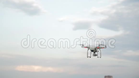 白色无人驾驶飞机在城市背景下的蓝天上飞行视频的预览图
