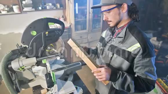 一个年轻的木匠在圆锯机上安装了一个木制工件家庭作坊新手商人视频的预览图