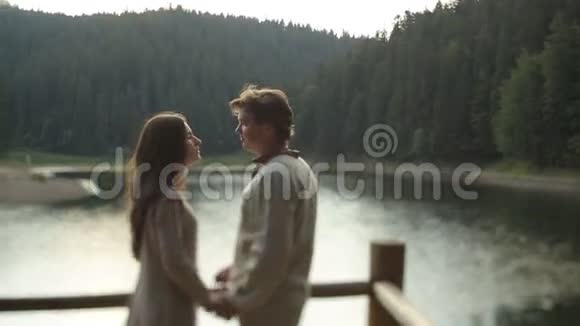 美丽的夫妻相爱穿着传统的乌克兰服装轻轻地拥抱在山湖码头上呼吸视频的预览图